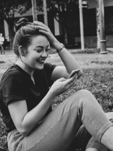 Une étudiant détendue sourit pendant une visio sur son téléphone